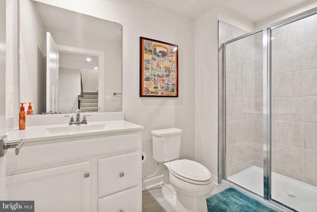 full bath featuring toilet, a shower stall, baseboards, and vanity