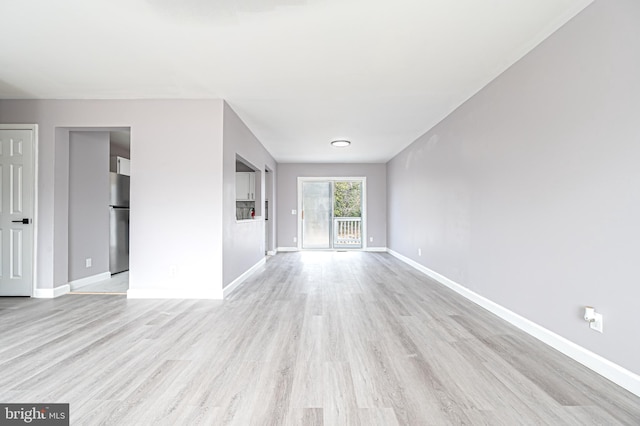 unfurnished living room featuring light wood-style flooring and baseboards