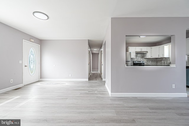 foyer entrance with light wood finished floors and baseboards