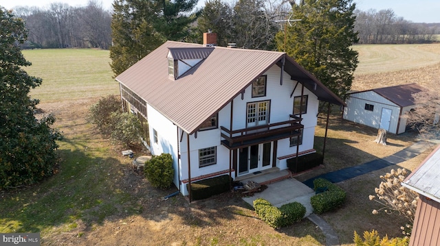 view of front of property featuring a front yard, french doors, metal roof, and a chimney