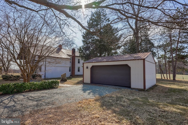 view of front of house with an outbuilding, metal roof, and a detached garage