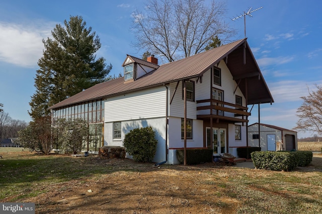 view of front of home with stucco siding, a chimney, metal roof, and french doors