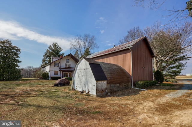 view of home's exterior with an outdoor structure and a lawn