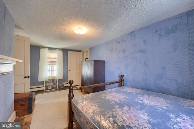 bedroom with a textured ceiling and wood finished floors