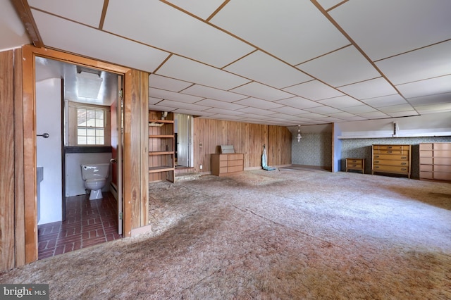 unfurnished living room featuring wooden walls