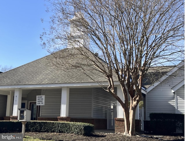 exterior space with covered porch and a shingled roof