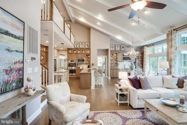 living room featuring visible vents, high vaulted ceiling, beamed ceiling, and light wood-style flooring