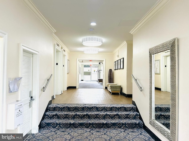 hallway featuring ornamental molding, baseboards, and stairs