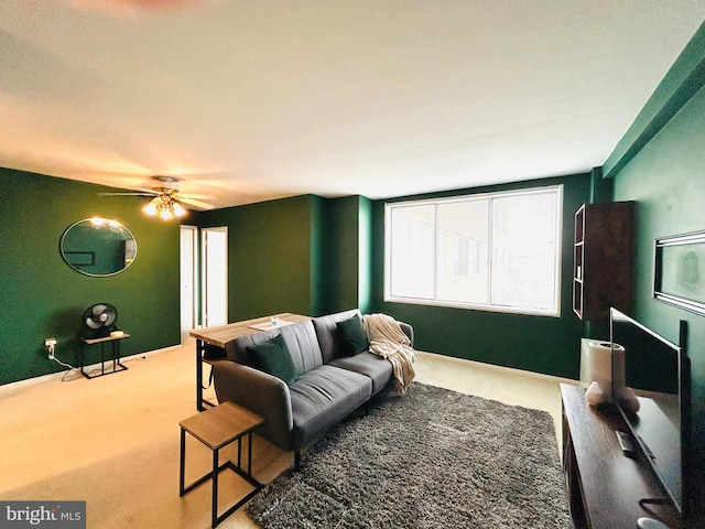 carpeted living room with a ceiling fan and baseboards