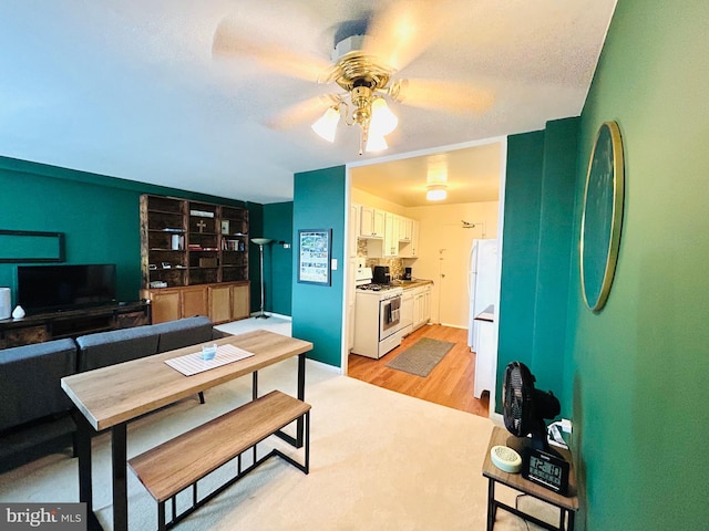 dining space featuring light wood finished floors and ceiling fan