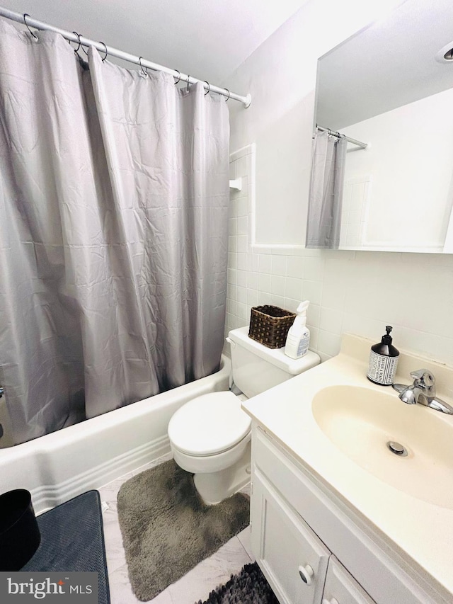 full bath featuring toilet, vanity, tile walls, decorative backsplash, and shower / bath combo