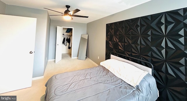 carpeted bedroom with a closet, baseboards, and a ceiling fan