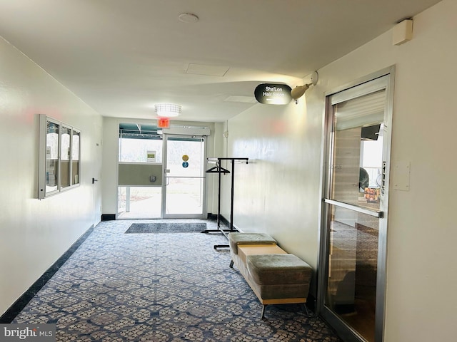 corridor with carpet flooring and baseboards