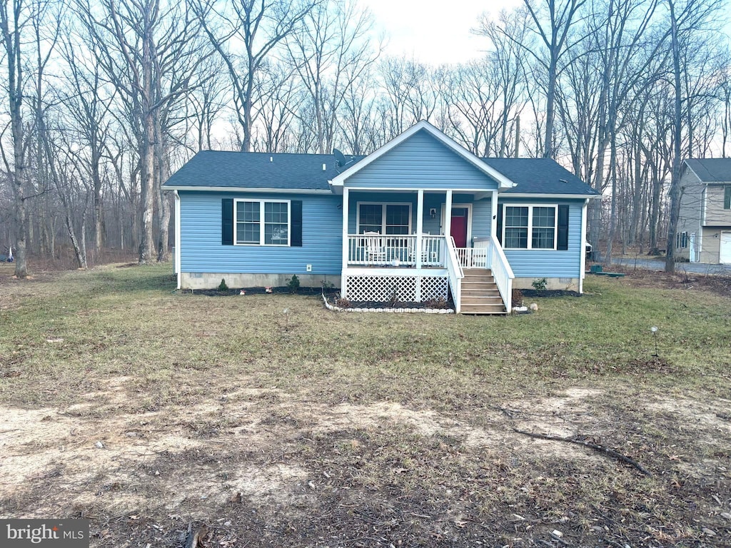 view of front of house with a front lawn, covered porch, roof with shingles, and crawl space