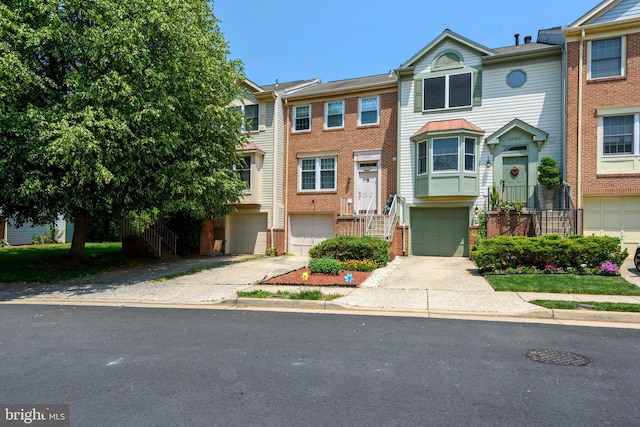 view of property featuring brick siding, driveway, stairway, and an attached garage