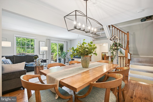 dining space featuring light wood finished floors and stairs