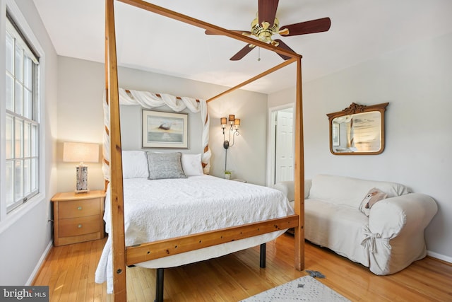 bedroom featuring a ceiling fan, baseboards, and light wood finished floors