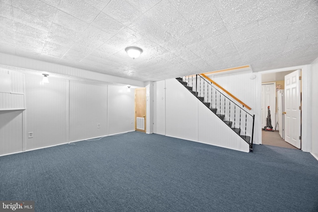 finished below grade area featuring stairs, carpet flooring, and visible vents