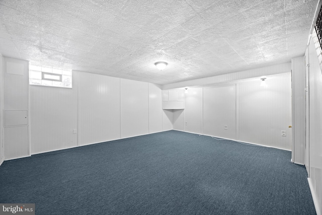 basement featuring carpet floors and a textured ceiling