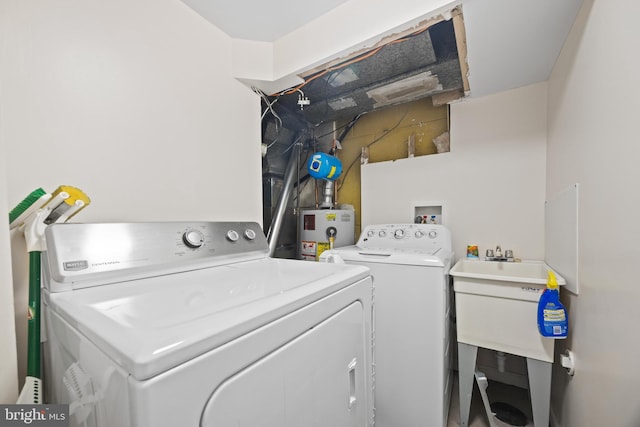 laundry area featuring water heater, laundry area, and washing machine and clothes dryer