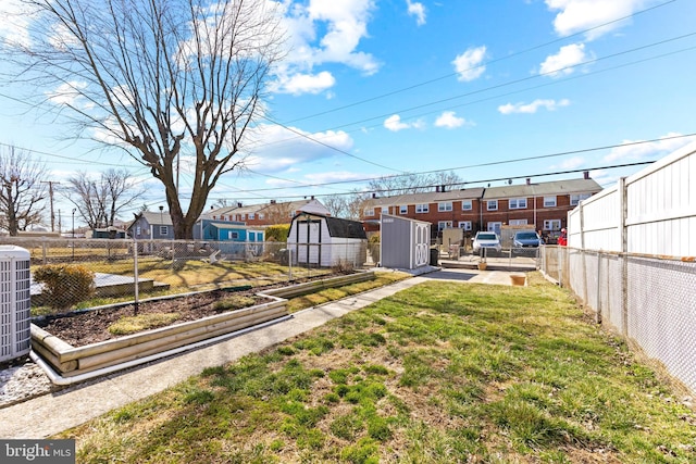 view of yard featuring a fenced backyard, a residential view, an outdoor structure, and a shed