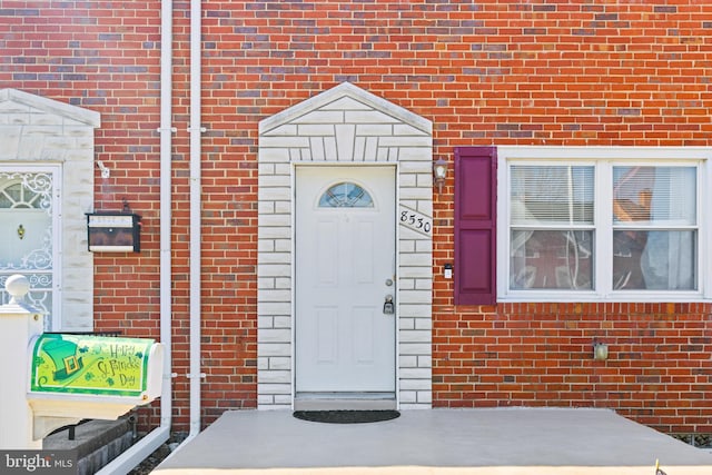 doorway to property with brick siding