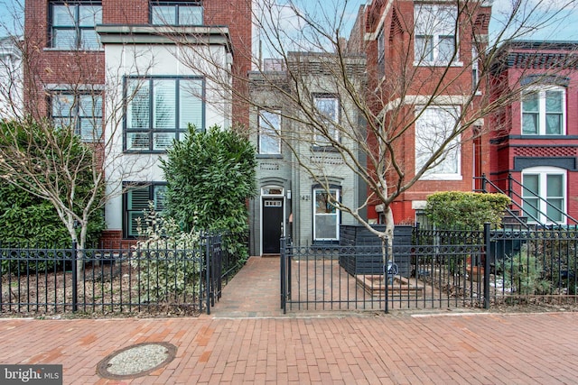 view of front of property featuring brick siding and a fenced front yard