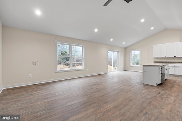 unfurnished living room with lofted ceiling, recessed lighting, a ceiling fan, wood finished floors, and baseboards