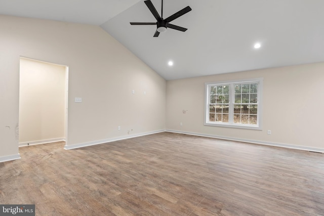 empty room featuring ceiling fan, vaulted ceiling, baseboards, and wood finished floors