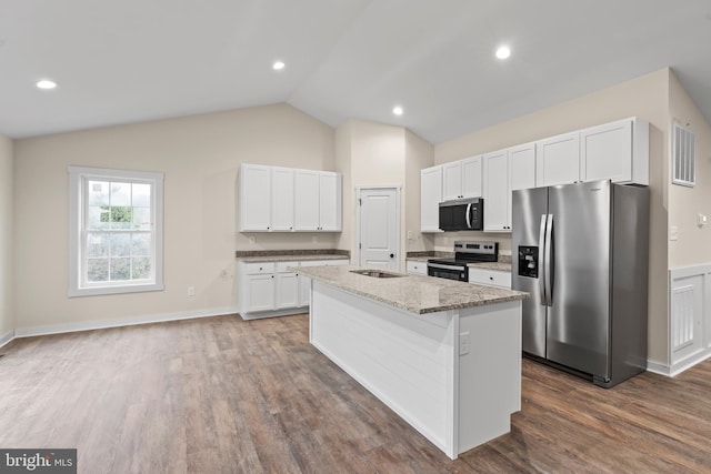 kitchen with lofted ceiling, a kitchen island with sink, visible vents, white cabinets, and appliances with stainless steel finishes