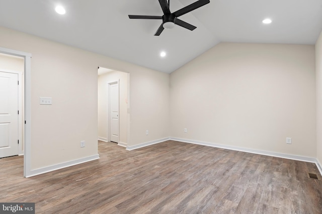 spare room featuring vaulted ceiling, wood finished floors, a ceiling fan, and baseboards