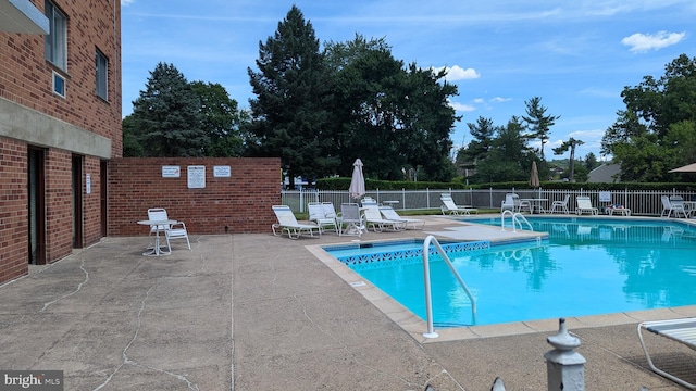 community pool featuring fence and a patio