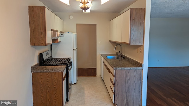 kitchen with a sink, white cabinetry, ventilation hood, dark countertops, and stainless steel range with gas stovetop