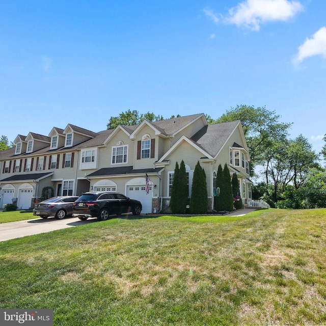 view of front facade featuring concrete driveway, an attached garage, a residential view, and a front yard