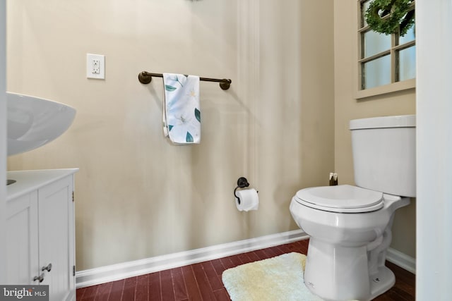 bathroom featuring wood finished floors, toilet, and baseboards