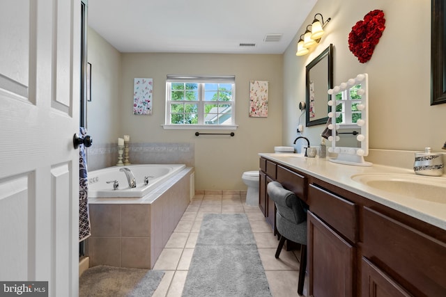 bathroom with double vanity, visible vents, tile patterned floors, a garden tub, and a sink