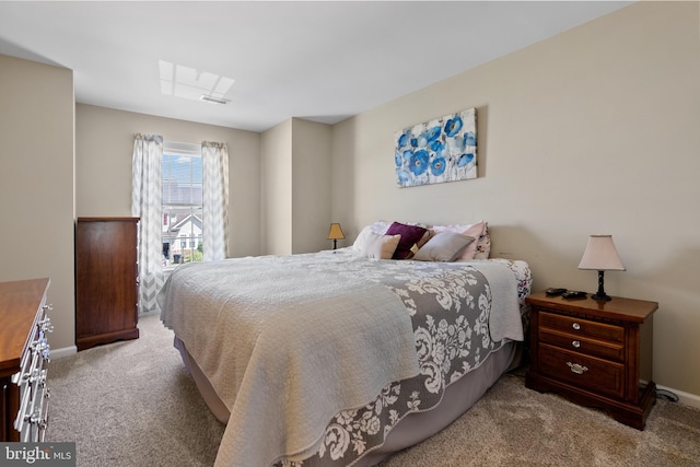 carpeted bedroom with a skylight and baseboards