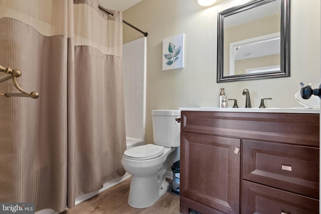 bathroom with toilet, shower / tub combo, wood finished floors, and vanity