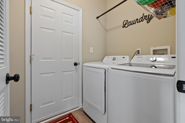 washroom with washing machine and dryer, laundry area, and wood finished floors