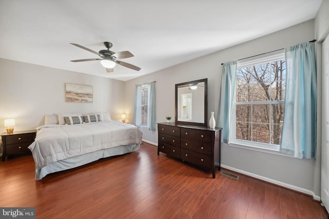 bedroom with visible vents, baseboards, and wood finished floors