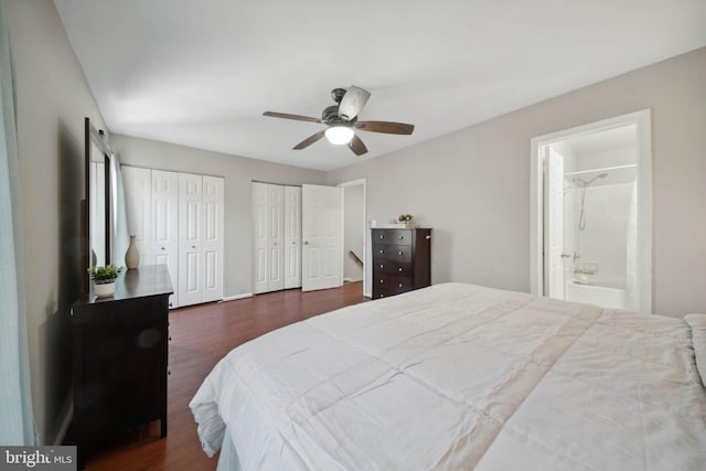 bedroom featuring connected bathroom, multiple closets, a ceiling fan, and dark wood-style flooring