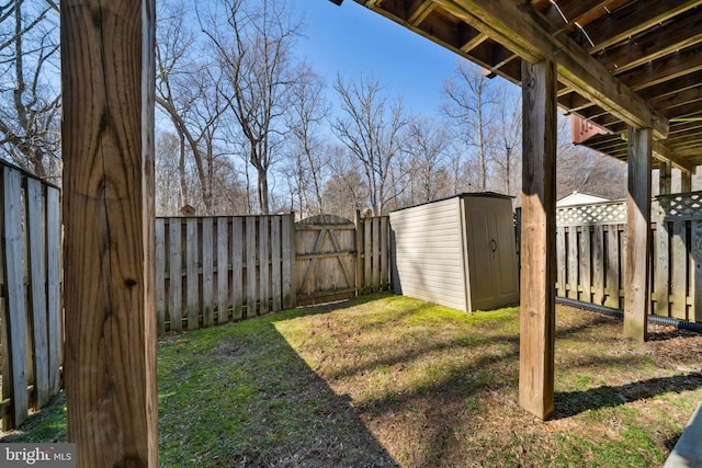 view of yard featuring an outbuilding, a storage shed, a fenced backyard, and a gate