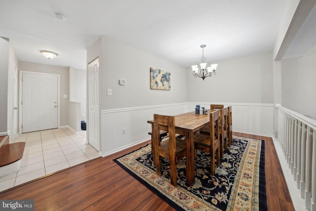 dining room featuring a chandelier, wainscoting, and wood finished floors