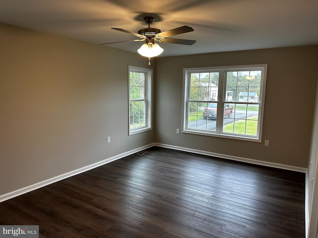 empty room featuring dark wood-style floors, ceiling fan, and baseboards