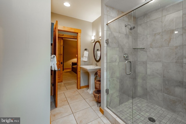 bathroom featuring baseboards, a stall shower, and tile patterned flooring