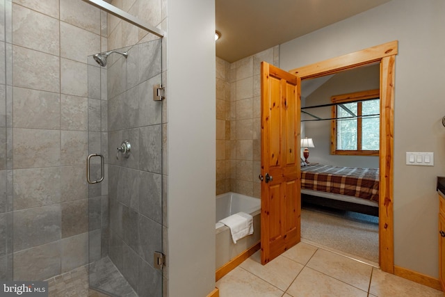 full bathroom featuring a shower stall, a bath, ensuite bathroom, and tile patterned flooring