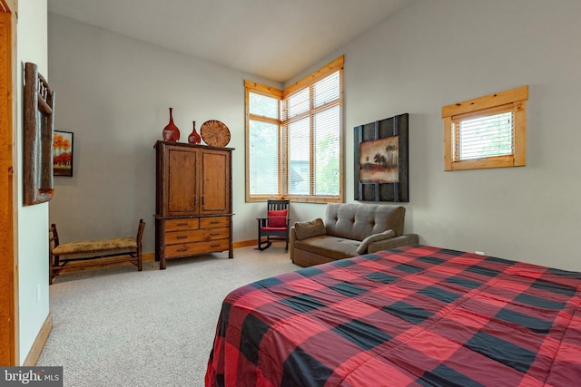 bedroom with light carpet, multiple windows, and baseboards