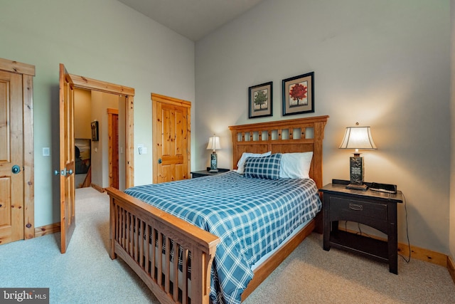 bedroom with baseboards, carpet, and a towering ceiling