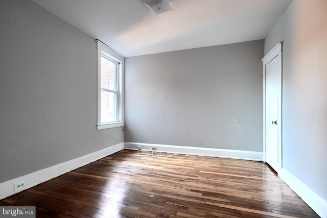 empty room with baseboards and hardwood / wood-style floors