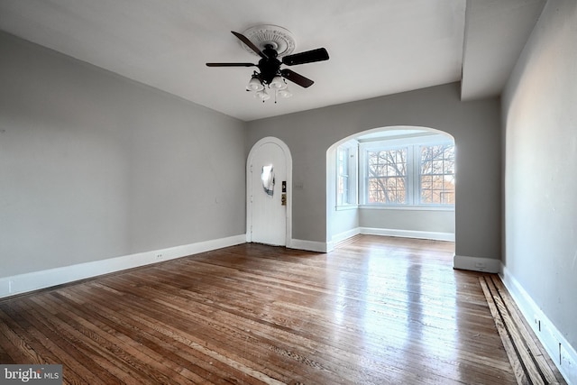 foyer with a ceiling fan, wood-type flooring, and baseboards